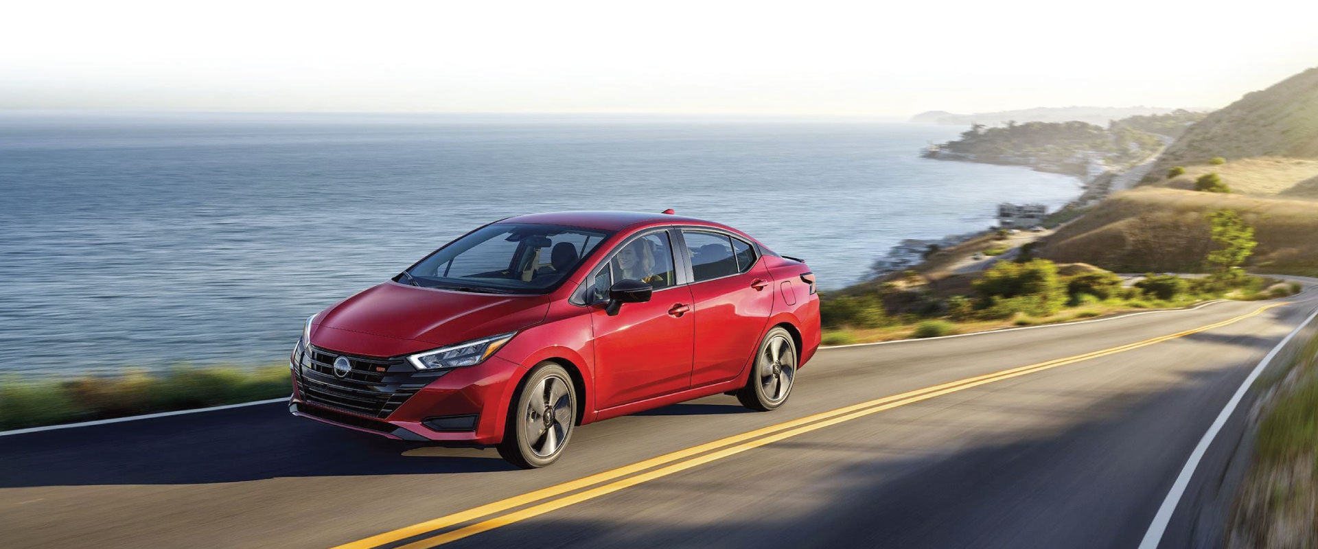 2025 Nissan Versa driving on a coastal road along a bluff